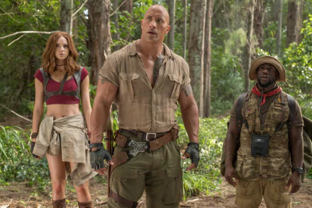 HD wallpaper of 'Jumanji: Welcome to the Jungle' featuring Kevin Hart, Karen Gillan, and Dwayne Johnson in a forest setting. 