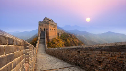 HD wallpaper showing a serene landscape of the Great Wall of China at sunset, with mountains in the background.