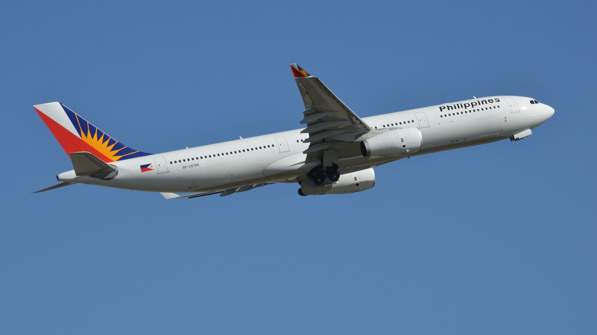 HD wallpaper of a Philippine Airlines Airbus A330 passenger plane flying against a clear blue sky, showcasing the sleek aircraft design and vibrant tail colors.