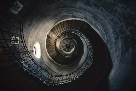 HD desktop wallpaper featuring a stunning man-made spiral staircase winding upwards, captured with rich detail and shadow play, creating a mesmerizing visual effect.