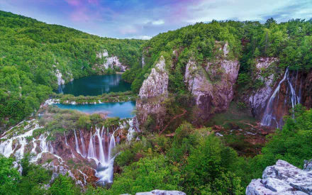 2K Quad HD PC desktop wallpaper of Plitvice Lakes National Park, Croatia, showing lush forest, cascading waterfalls and turquoise lakes in vibrant natural beauty.