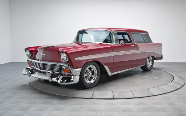 Red 1956 Chevrolet Bel Air Nomad station wagon on a studio turntable, classic Chevrolet vehicle — 2K Quad HD PC desktop wallpaper/background.