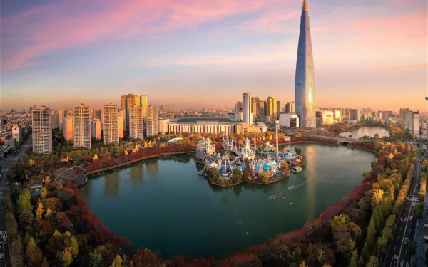 A vibrant cityscape of Seoul, South Korea, featuring a tall skyscraper, a lake surrounded by trees, and colorful buildings under a soft sunset sky.