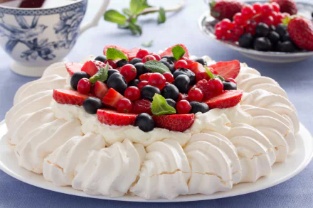 HD PC desktop wallpaper of a pavlova dessert: crisp white meringue topped with strawberries, blueberries, mixed berries and fresh mint.