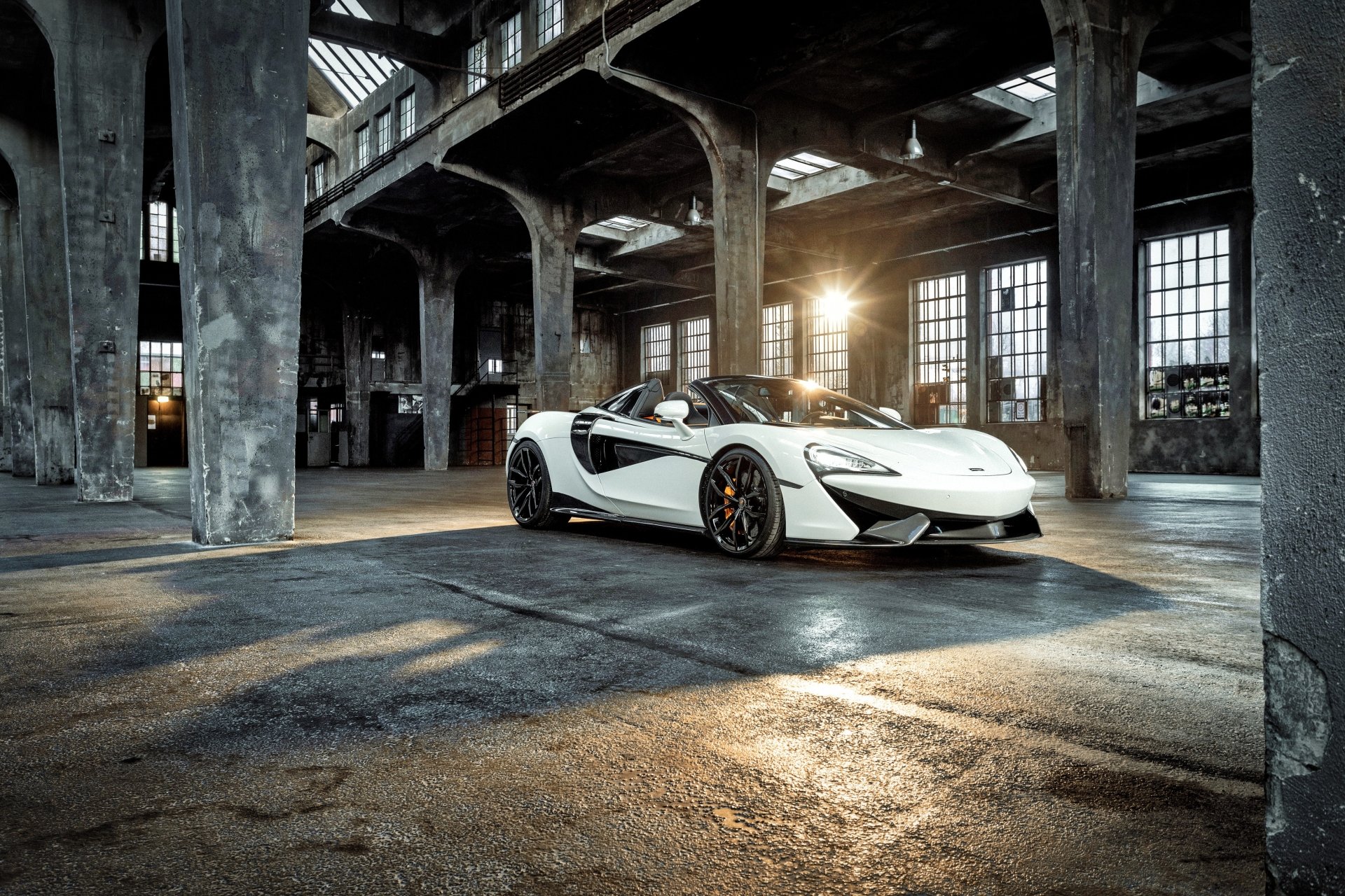 White McLaren 570S supercar parked inside a spacious industrial warehouse, captured in stunning 4K Ultra HD for a dynamic PC desktop wallpaper.