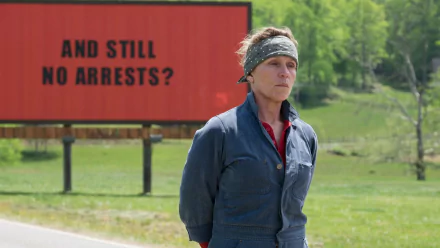 HD desktop wallpaper featuring a still from Three Billboards Outside Ebbing, Missouri with Frances McDormand standing in front of a billboard.