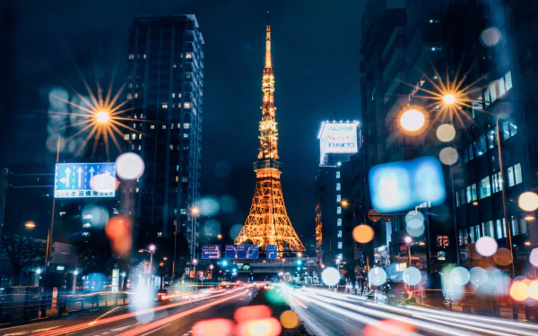 Tokyo Tower illuminated at night with time-lapse light trails and bokeh effects highlighting skyscrapers in the vibrant cityscape of Tokyo, Japan.