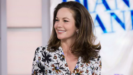 HD desktop wallpaper featuring a smiling woman with shoulder-length brown hair, wearing a floral top against a blurred background.