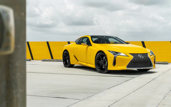 Yellow Lexus LC 500 supercar parked on a rooftop against a yellow-striped barrier and cloudy sky, presented as an 8K Ultra HD PC desktop wallpaper/background.