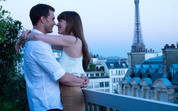 HD desktop wallpaper of a couple embracing with the Eiffel Tower in the background, from Fifty Shades Freed.