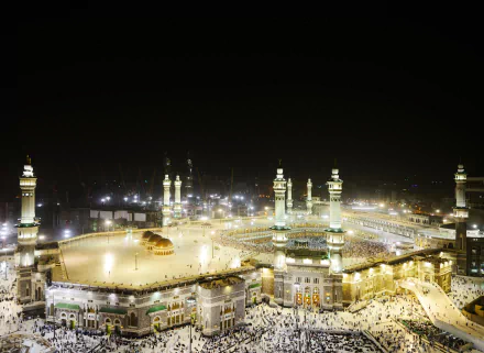 A stunning HD wallpaper of Masjid al-Haram in Mecca, capturing the illuminated mosque and bustling atmosphere at night.