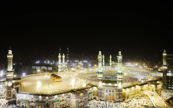 A stunning HD wallpaper of Masjid al-Haram in Mecca, capturing the illuminated mosque and bustling atmosphere at night.