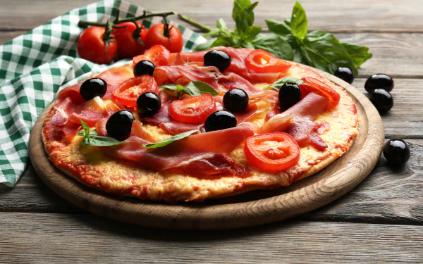 5K Ultra HD PC desktop wallpaper: still-life food image of a pizza on a wooden board topped with black olives, sliced tomatoes and fresh basil.