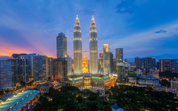 A night view of Kuala Lumpur's cityscape featuring the illuminated Petronas Towers and surrounding skyscrapers in Malaysia.
