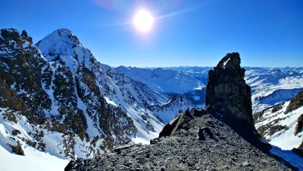 Snow-covered alpine landscape in Tyrol, featuring rugged mountains under a clear winter sky with bright sunlight, captured in HD for a desktop wallpaper background.