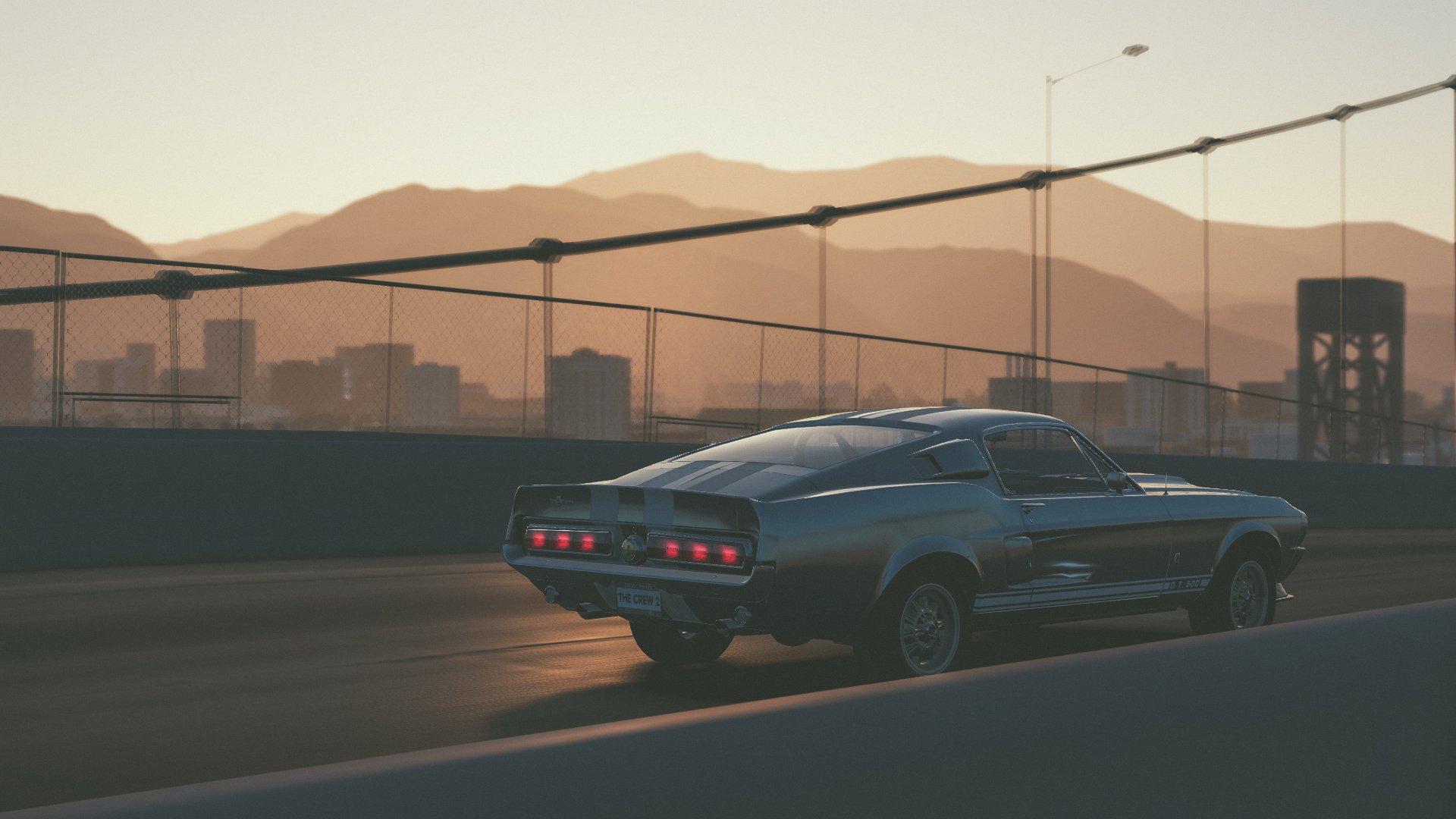 4K Ultra HD PC desktop wallpaper of a Ford Mustang GT500 crossing a bridge at sunset in The Crew 2 video game.