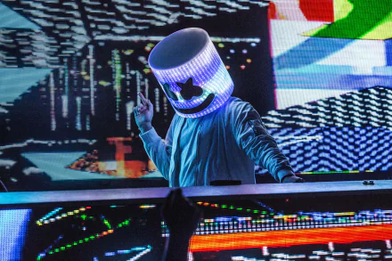 HD desktop wallpaper of DJ Marshmello performing on stage, wearing his iconic LED helmet, surrounded by vibrant digital graphics and music-themed visuals.