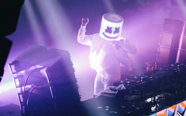 HD desktop wallpaper featuring Marshmello, the DJ, performing on stage with vibrant lights and equipment, creating a dynamic music atmosphere.