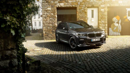 Black BMW X3 SUV parked on a cobblestone driveway in front of a stone building, captured in 4K Ultra HD.