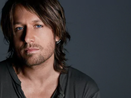HD desktop wallpaper featuring a close-up of musician Keith Urban, with a moody grey background.