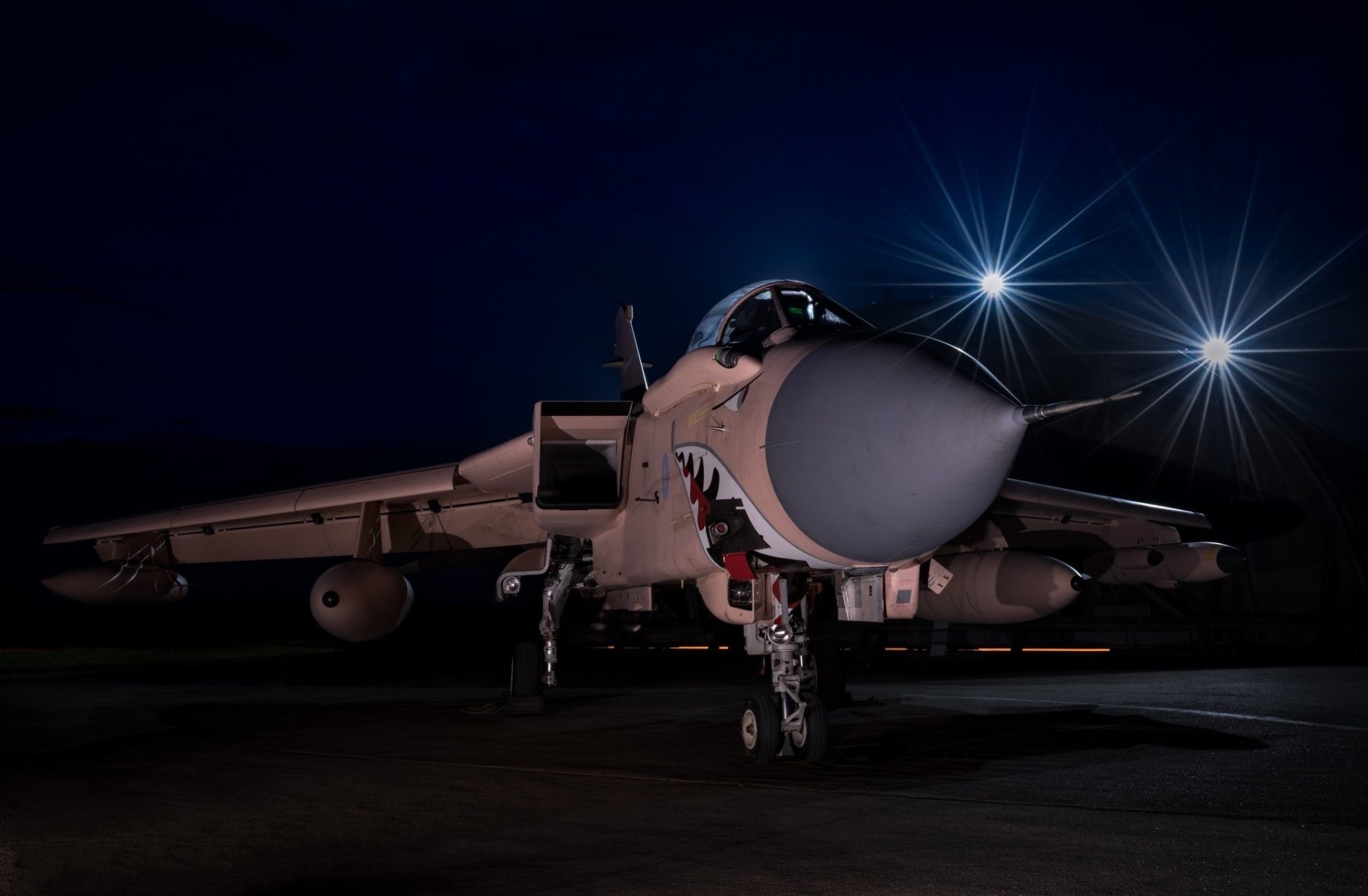 HD desktop wallpaper featuring a Panavia Tornado jet fighter warplane illuminated against a dark night sky, showcasing its military aircraft design.