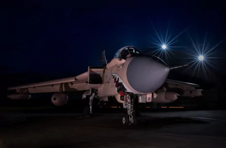 HD desktop wallpaper featuring a Panavia Tornado jet fighter warplane illuminated against a dark night sky, showcasing its military aircraft design.