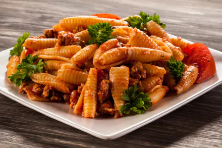 Close-up of pasta with meat sauce and parsley on a white plate, captured in vibrant detail for a 4K Ultra HD PC desktop wallpaper and background.