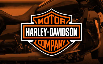 Harley-Davidson logo on a desktop wallpaper with a motorcycle blurred in the background.