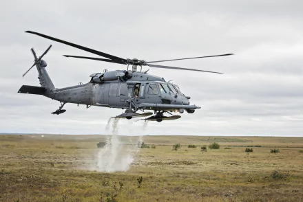 Military Sikorsky HH-60 Pave Hawk helicopter hovers low over open terrain, captured in 4K Ultra HD as a striking PC desktop wallpaper background.