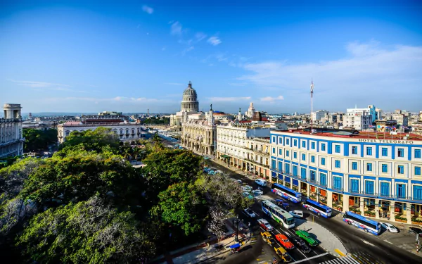 HD desktop wallpaper showcasing a vibrant man-made cityscape of Havana with classic architecture, lush greenery, and a bright blue sky.