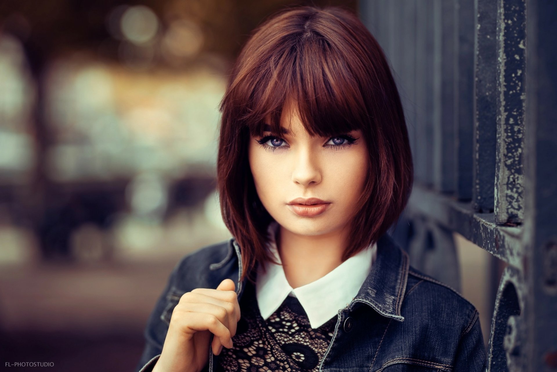 Portrait of French model Marie Grippon with short brunette hair and striking blue eyes, captured in sharp focus against a softly blurred background.