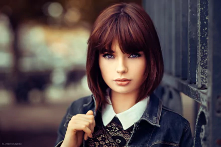 Portrait of French model Marie Grippon with short brunette hair and striking blue eyes, captured in sharp focus against a softly blurred background.