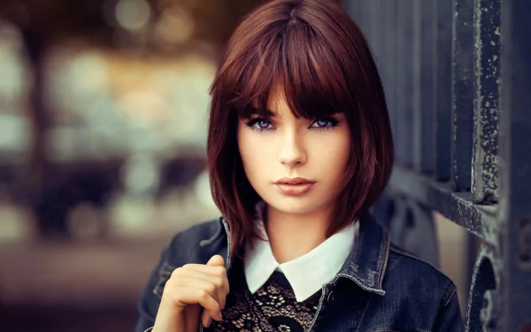 Portrait of French model Marie Grippon with short brunette hair and striking blue eyes, captured in sharp focus against a softly blurred background.