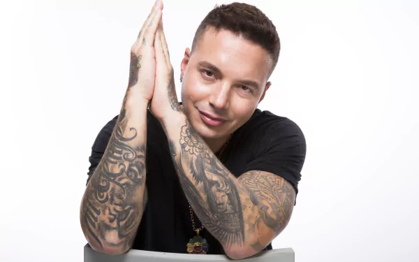 HD wallpaper and background featuring a smiling individual with hands together above head and detailed arm tattoos.