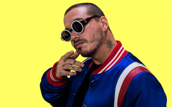 HD wallpaper featuring a person in sunglasses and a blue-red jacket against a yellow background.