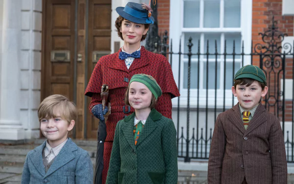 HD wallpaper featuring characters from Mary Poppins Returns, with Mary Poppins and three children in vintage attire standing in front of a house.