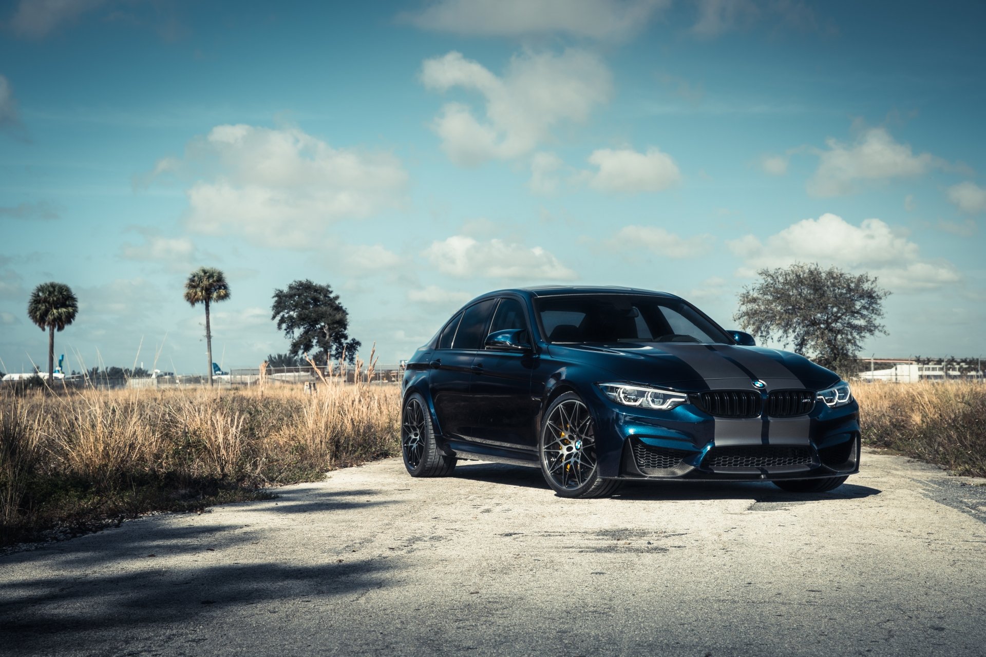 A sleek black BMW M3 car parked on a rural road under a partly cloudy sky, captured in stunning 4K Ultra HD as a PC desktop wallpaper and background.