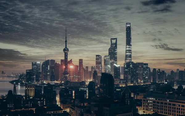 HD desktop wallpaper showcasing the man-made Oriental Pearl Tower and Shanghai skyline in China at dusk under a cloudy sky.