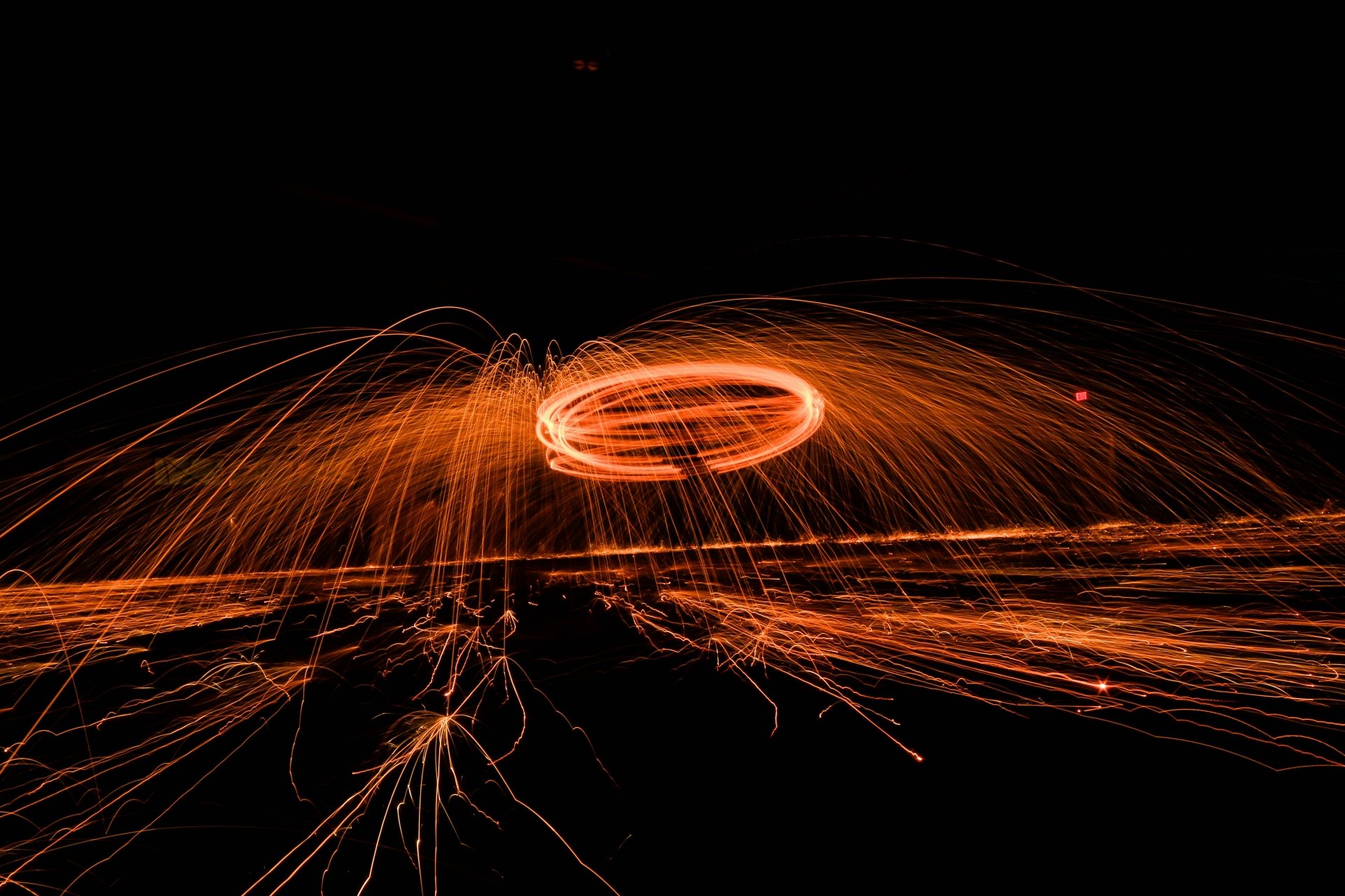 Vibrant orange fireworks captured in dynamic motion against a black background, displayed as a stunning 4K Ultra HD photography wallpaper for PC desktop.