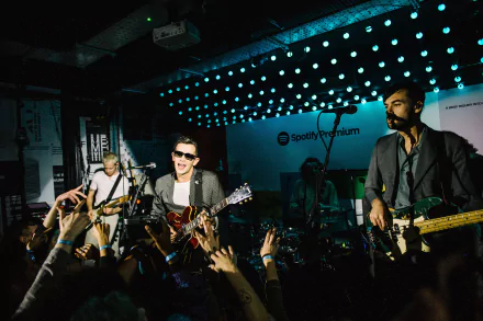 A vibrant HD desktop wallpaper featuring The 1975 performing live, with an enthusiastic crowd and dynamic lighting, capturing the energy of the music scene.