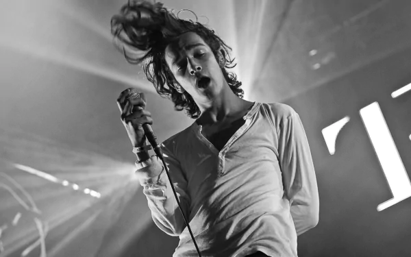 HD wallpaper of The 1975 in concert with a dynamic black and white image of the lead singer performing.
